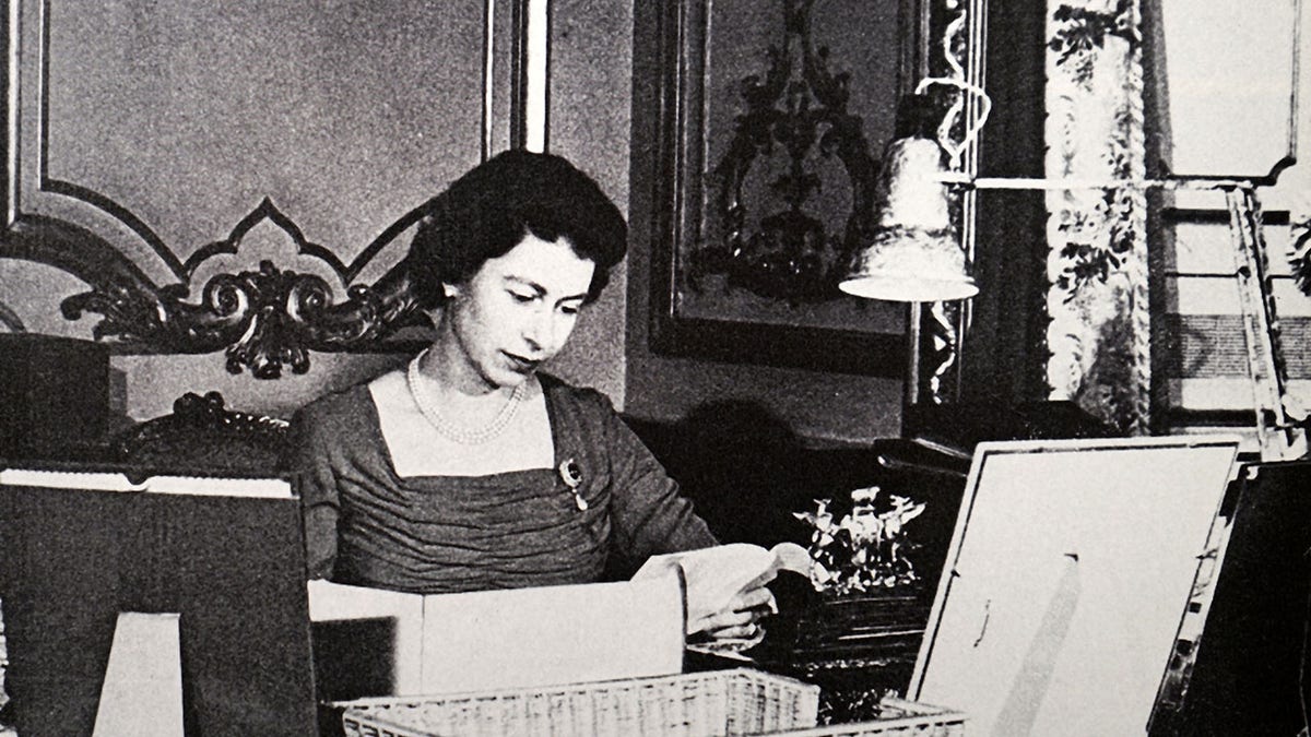 The queen sitting at her desk in 1956