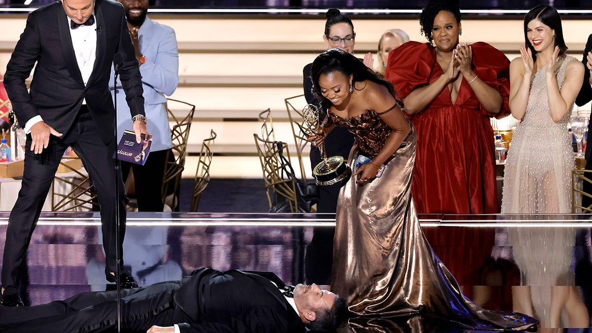 Quinta Brunson talks to Jimmy Kimmel while he's lying down on stage