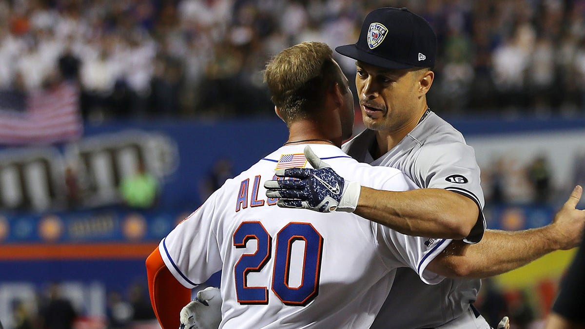 Pete Alonso hugs Giancarlo Stanton