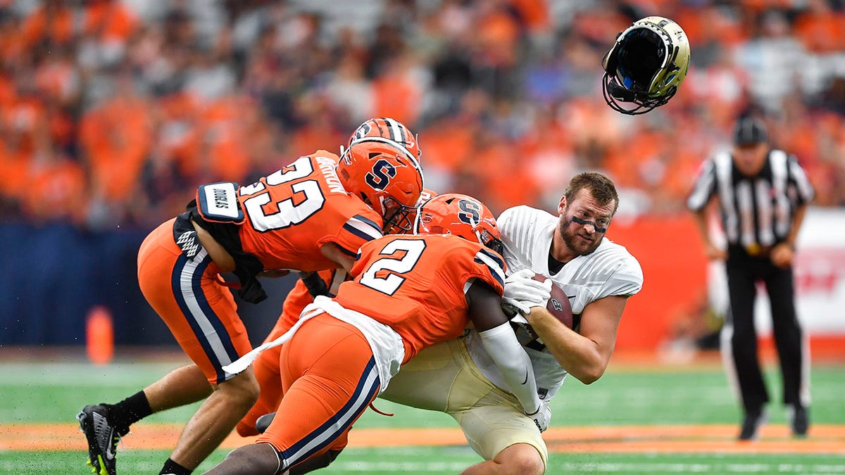 Syracuse players tackle Purdue ball carrier