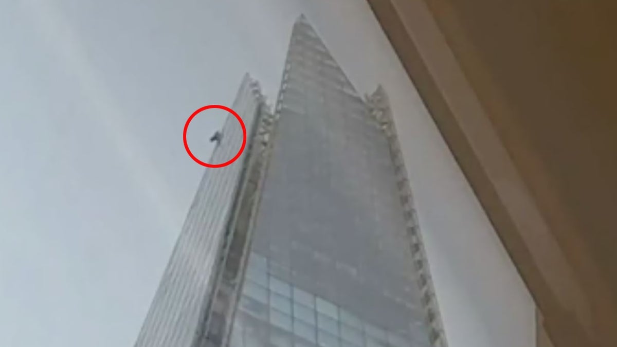 man climbing building in London