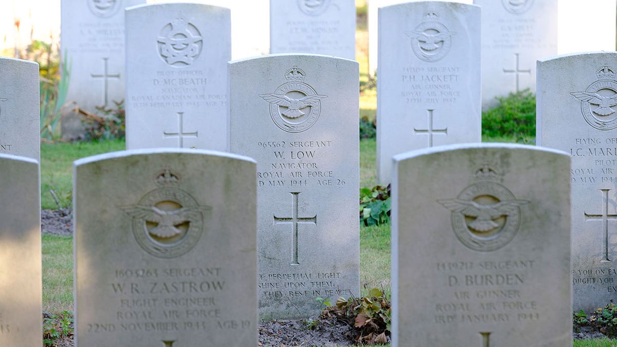 White gravestone heads with names of soldiers during daytime