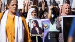 Women carry pictures during a protest over the death of 22-year-old Kurdish woman Mahsa Amini in Iran, in the Kurdish-controlled city of Qamishli, northeastern Syria September 26, 2022.