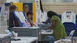 A women in a green dress checking in at a polling location to vote