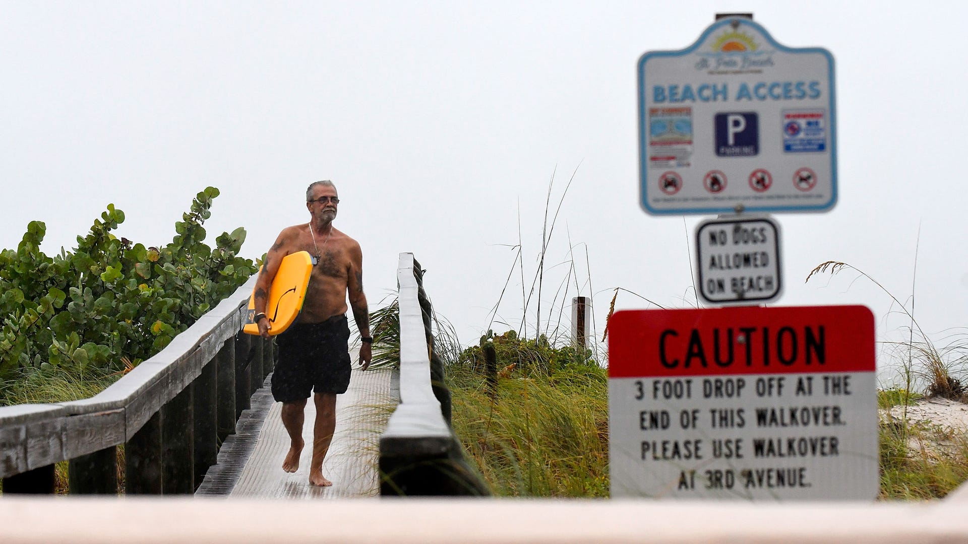 A Florida resident walks along a Florida beach during Hurricane Ian