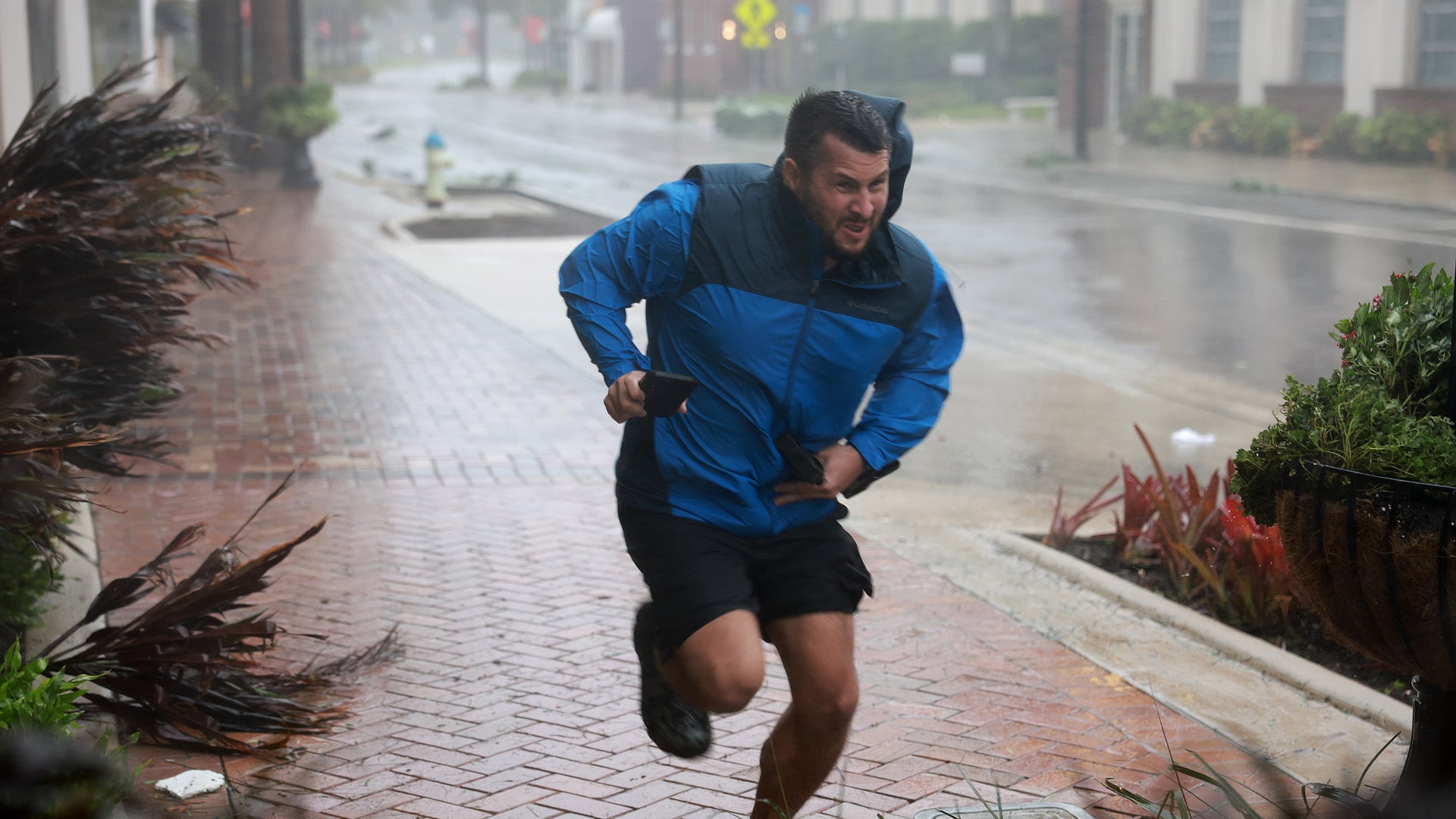 A man runs through the strets during Hurricane Ian as it hits Florida