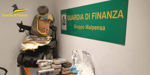 This picture made available Friday, Sep. 2, 2022, by the Italian Financial Police shows the motorized wheelchair used by a man who tried to sniff some 13 kilos (nearly 30 pounds) of cocaine, foreground, at Milan airport, northern Italy.
