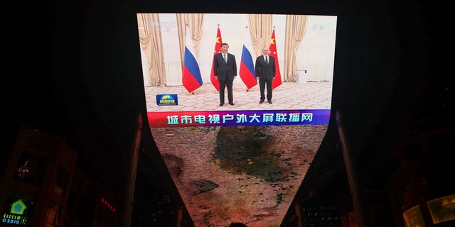 A giant screen broadcasts news footage of Chinese President Xi Jinping and Russian President Vladimir Putin posing for pictures during a meeting on the sidelines of the Shanghai Cooperation Organization (SCO) summit in Uzbekistan, in Beijing, China, September 16, 2022. 