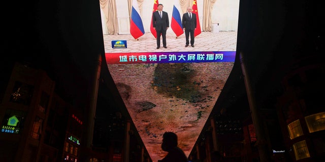 A giant screen broadcasts news footage of Chinese President Xi Jinping and Russian President Vladimir Putin posing for pictures during a meeting on the sidelines of the Shanghai Cooperation Organization (SCO) summit in Uzbekistan, in Beijing, China, September 16, 2022.