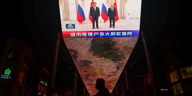 Chinese President Xi Jinping and Russian President Vladimir Putin pose for a picture during a bystander meeting of the Shanghai Cooperation Organization (SCO) summit in Uzbekistan in Beijing, China, 16 September 2022 A huge screen is broadcasting the news footage that is being taken. 