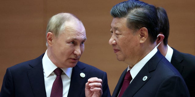 Russian President Vladimir Putin speaks with Chinese President Xi Jinping before an extended-format meeting of heads of the Shanghai Cooperation Organization (SCO) member states in Samarkand, Uzbekistan, September 16, 2022. 