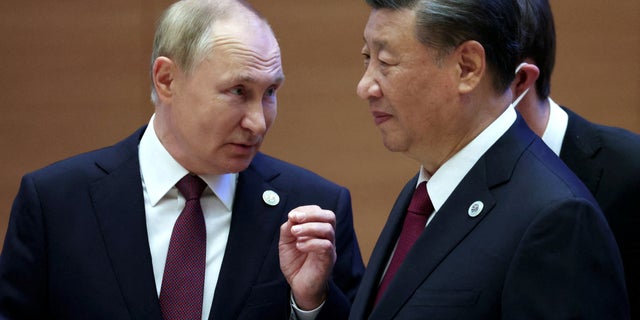 Russian President Vladimir Putin speaks with Chinese President Xi Jinping before an extended-format meeting of heads of the Shanghai Cooperation Organization (SCO) member states in Samarkand, Uzbekistan, September 16, 2022.