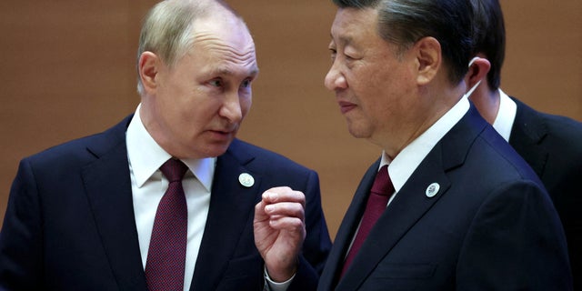 Russian President Vladimir Putin speaks with Chinese President Xi Jinping before an extended-format meeting of heads of the Shanghai Cooperation Organization (SCO) member states in Samarkand, Uzbekistan, September 16, 2022. 