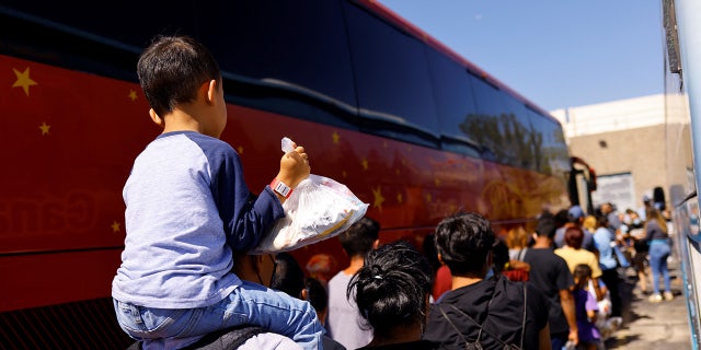 Migrants queue to board a charter bus outside the El Paso Migrant Welcome Center in El Paso, Texas. The city has sent more than 100 busloads of migrants to New York City and Chicago.