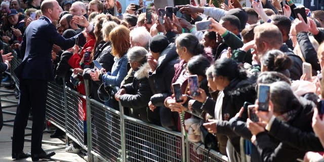 Britain's William, Prince of Wales greets people in line to pay their respects to Britain's Queen Elizabeth following her death, in London, Sept. 17, 2022. 