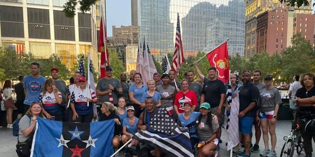 Participants in the 9/11 Promise Run last year proudly wave flags at the finish line on Sept. 11, 2021.