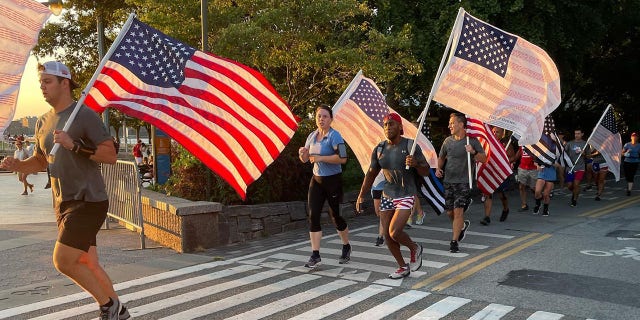 9/11 Promise Run participants are shown participating with American flags at the end of the race on Sept. 11, 2021.