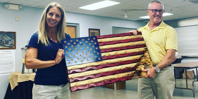 9/11 Promise founder and president Jen Depoto (left) holds a wood-carved American flag at Vienna Volunteer Fire Department on Sept. 8, 2022.