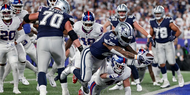 Dallas Cowboys running back Ezekiel Elliott, #21, leaps across the goal line for a touchdown against the New York Giants during the third quarter of an NFL football game, Monday, Sept. 26, 2022, in East Rutherford, New Jersey.