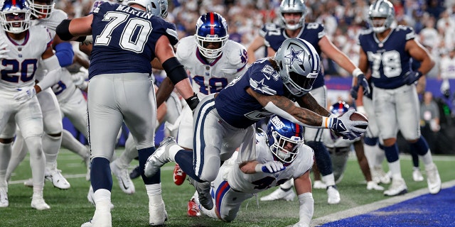 Dallas Cowboys running back Ezekiel Elliott, #21, leaps across the goal line for a touchdown against the New York Giants during the third quarter of an NFL football game, Monday, Sept. 26, 2022, in East Rutherford, New Jersey.