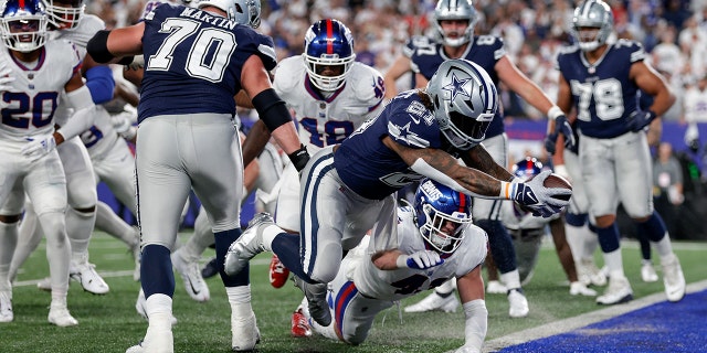 Dallas Cowboys running back Ezekiel Elliott (#21) scores for a touchdown against the New York Giants during the third quarter of an NFL football game in East Rutherford, New Jersey, Monday, September 26, 2022. Jump over the line.