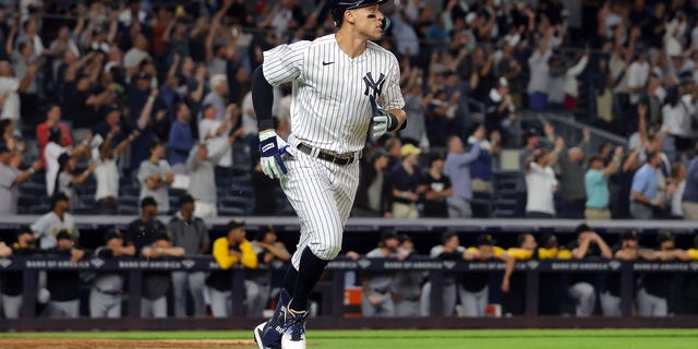 Aaron Judge #99 of the New York Yankees hits his 60th home run of the season during the 9th inning of the game against the Pittsburgh Pirates at Yankee Stadium on September 20, 2022, in the Bronx borough of New York City.