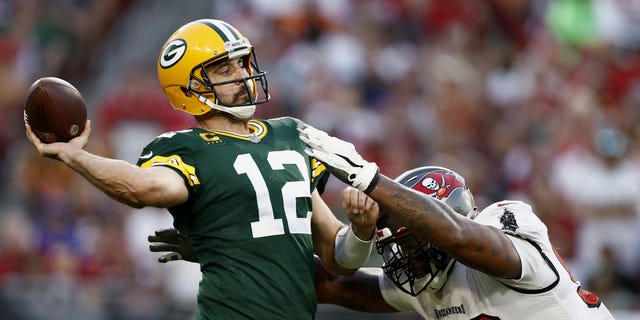 Aaron Rodgers #12 of the Green Bay Packers throws a pass with pressure from William Gholston #92 of the Tampa Bay Buccaneers during the fourth quarter in the game at Raymond James Stadium on September 25, 2022 in Tampa, Florida.