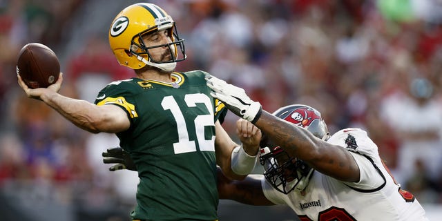 Aaron Rodgers #12 of the Green Bay Packers throws a pass with pressure from William Gholston #92 of the Tampa Bay Buccaneers during the fourth quarter in the game at Raymond James Stadium on September 25, 2022 in Tampa, Florida.