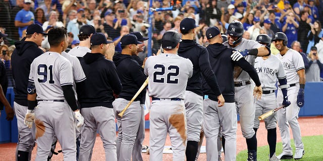 Aaron Judge #99 of the New York Yankees is congratulated by teammates after hitting his 61st home run of the season in the seventh inning against the Toronto Blue Jays at Rogers Centre on Sept. 28, 2022 in Toronto, Ontario, Canada. Judge has now tied Roger Maris for the American League record. 