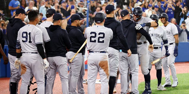 Aaron Judge #99 of the New York Yankees is congratulated by teammates after hitting his 61st home run of the season in the seventh inning against the Toronto Blue Jays at Rogers Centre on Sept. 28, 2022 in Toronto, Ontario, Canada. Judge has now tied Roger Maris for the American League record. 