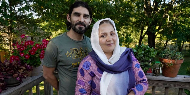 Mohammad Walizada, left, and his wife Mariam, right, who fled Afghanistan with their family, stand for a portrait, Thursday, Sept. 15, 2022, at their home, in Epping, N.H. Since the U.S. military’s withdrawal from Kabul last year, the Sponsor Circle Program for Afghans has helped over 600 Afghans restart their lives in their communities. Now the Biden administration is preparing to turn the experiment into a private-sponsorship program for refugees admitted through the U.S. Refugee Admissions Program and is asking organizations to team up with it to launch a pilot program by the end of 2022. (AP Photo/Steven Senne)