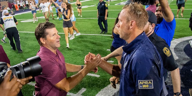 Old Dominion head coach Ricky Rahne, right, shakes hands with Virginia Tech coach Brent Perry after the Old Dominion's win on Friday, Sept. 2, 2022, in Norfolk, Virginia. 