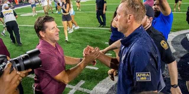 Old Dominion coach Ricky Rahne, right, shakes hands with Virginia Tech coach Brent Pry after Old Dominion's win Friday, Sept. 2, 2022, in Norfolk, Va. 