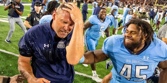 Old Dominion coach Ricky Rahne reacts after being doused next to defensive tackle Denzel Lowry (45) after the team's win over Virginia Tech Friday, Sept. 2, 2022, in Norfolk, Va. 
