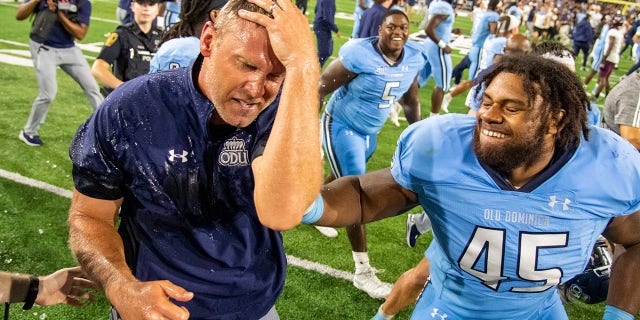 Old Dominion coach Ricky Rahne reacts after being doused next to defensive tackle Denzel Lowry (45) after the team's win over Virginia Tech Friday, Sept. 2, 2022, in Norfolk, Va. 