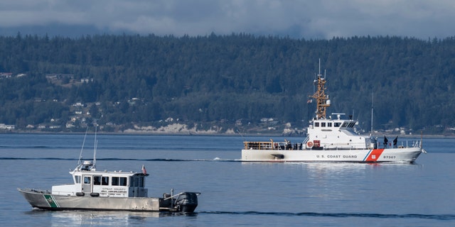 A U.S. Coast Guard boat and Kitsap, Wash., County Sherrif boat search the area, Monday, Sept. 5, 2022, near Freeland, Wash., on Whidbey Island north of Seattle where a chartered floatplane crashed the day before.
