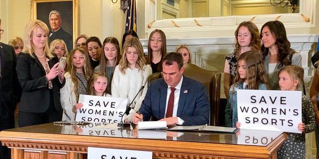 FILE - In this March 30, 2022 file photo Oklahoma Gov. Kevin Stitt signs a bill in Oklahoma City that prevents transgender girls and women from competing on female sports teams. (AP Photo/Sean Murphy, File)