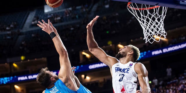 Slovenia's Luka Doncic, left, and France's Rudy Gobert fight for the ball during the EuroBasket Group B match in Cologne, Germany, on Sept. 7, 2022.