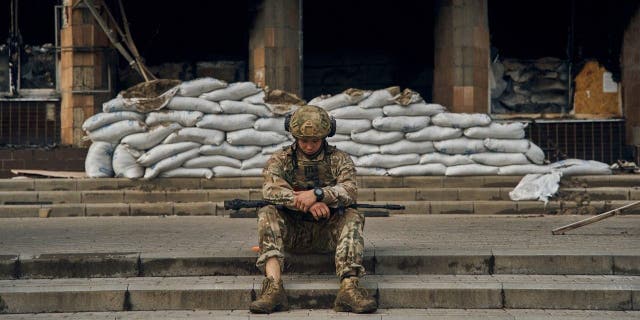 Ukrainian soldiers rest on the steps of the city hall in Izyum, Kharkiv region, Ukraine, Tuesday, September 13, 2022.