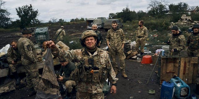 A Ukrainian soldier holds up the Russian flag to demonstrate in Izium, Kharkiv region, Ukraine, Tuesday, Sept. 13, 2022. Ukrainian troops piled pressure on retreating Russian forces Tuesday, pressing deeper into occupied territory and sending more Kremlin troops fleeing ahead of the counteroffensive that has inflicted a stunning blow on Moscow's military prestige. 
