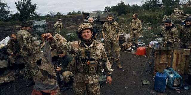 A Ukrainian soldier holds a defiled Russian flag in Izium, Kharkov region, Ukraine, Tuesday, September 13, 2022.