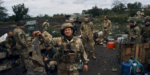 A Ukrainian soldier holds up the Russian flag to demonstrate in Izium, Kharkiv region, Ukraine, Tuesday, Sept. 13, 2022. Ukrainian troops piled pressure on retreating Russian forces Tuesday, pressing deeper into occupied territory and sending more Kremlin troops fleeing ahead of the counteroffensive that has inflicted a stunning blow on Moscow's military prestige. 