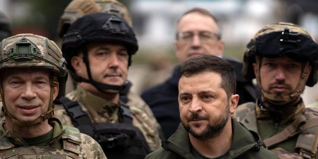 Ukrainian President Volodymyr Zelensky poses for a picture with soldiers after attending a flag-raising ceremony in Izium, liberated Ukraine, Wednesday, Sept. 14, 2022. 