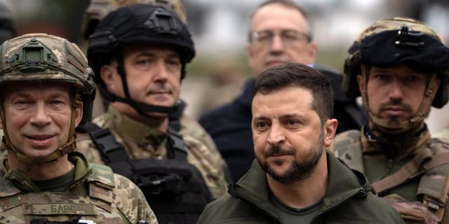 Ukrainian President Volodymyr Zelensky poses for a picture with soldiers after attending a flag-raising ceremony in Izium, liberated Ukraine, Wednesday, Sept. 14, 2022. 