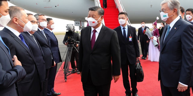 Chinese President Xi Jinping, center, is met by Kazakhstan's President Kassym-Jomart Tokayev, right, as he arrives at the Nur-sultan Nazarbayev International Airport for a state visit, Wednesday, Sept. 14, 2022.