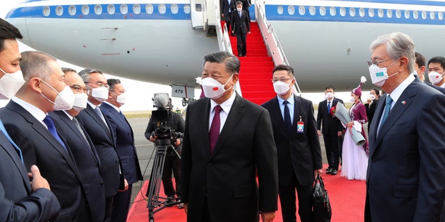 Chinese President Xi Jinping, center, is met by Kazakhstan's President Kassym-Jomart Tokayev, right, as he arrives at the Nur-sultan Nazarbayev International Airport for a state visit, Wednesday, Sept. 14, 2022.