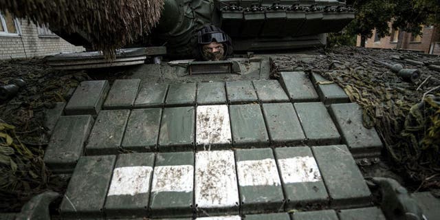 A Ukrainian serviceman sits in a tank in the recently retaken area of Izyum, Ukraine, on Sept. 14, 2022.