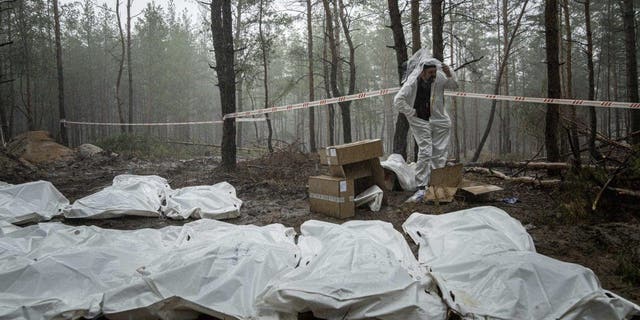 Bags with dead bodies are seen during the exhumation in the recently retaken area of Izium, Ukraine, Friday, Sept. 16, 2022. Ukrainian authorities discovered a mass burial site near the recaptured city of Izium that contained hundreds of graves. 