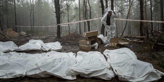 Bags with corpses are seen during the exhumation in the recently reconquered area of Izium, Ukraine on Friday, September 16, 2022. Ukrainian authorities have discovered a mass burial site near the reconquered city of Izium which contained hundreds of graves.
