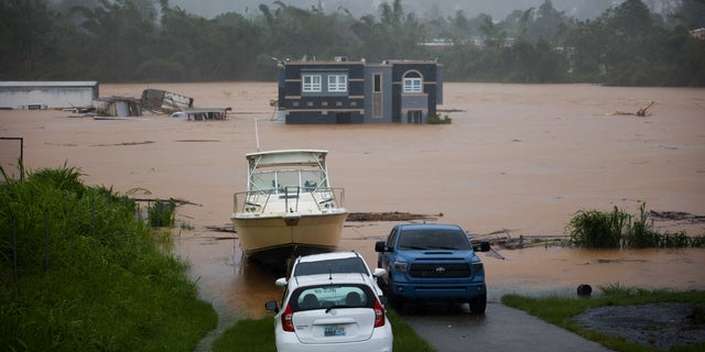 A home is submerged in floodwaters caused by Hurricane Fiona in Cayey, Puerto Rico, Sunday, Sept. 18, 2022.  According to authorities three people were inside the home and were reported to have been rescued.